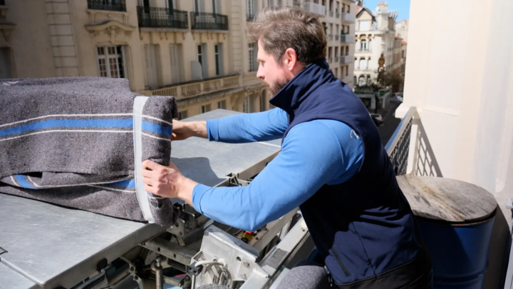 Déménageur protégeant un meuble sur un balcon avant le monte-meubles