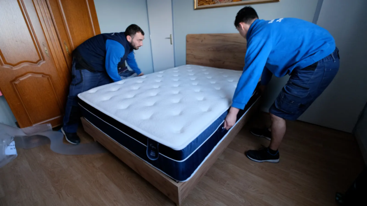 Déménageurs installant un matelas dans la nouvelle chambre