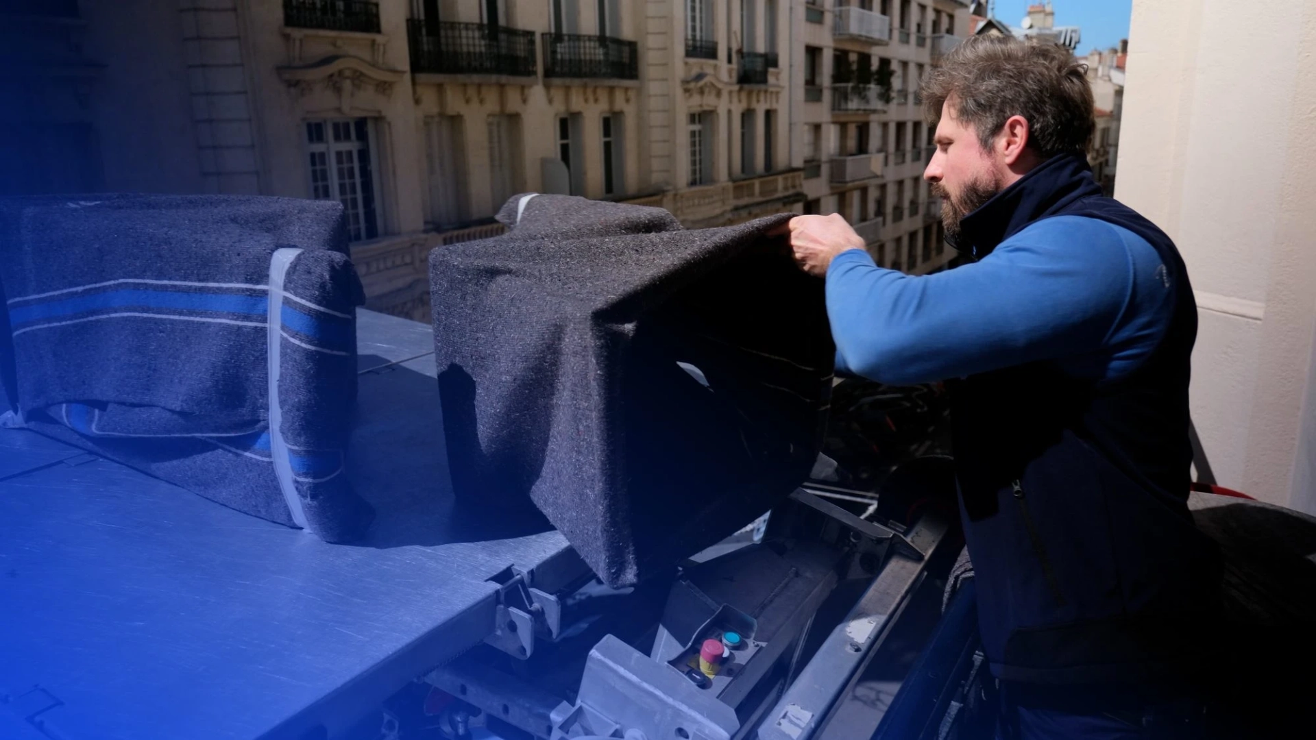 Déménageur Beaulaigue chargeant un meuble protégé sur le monte-meubles